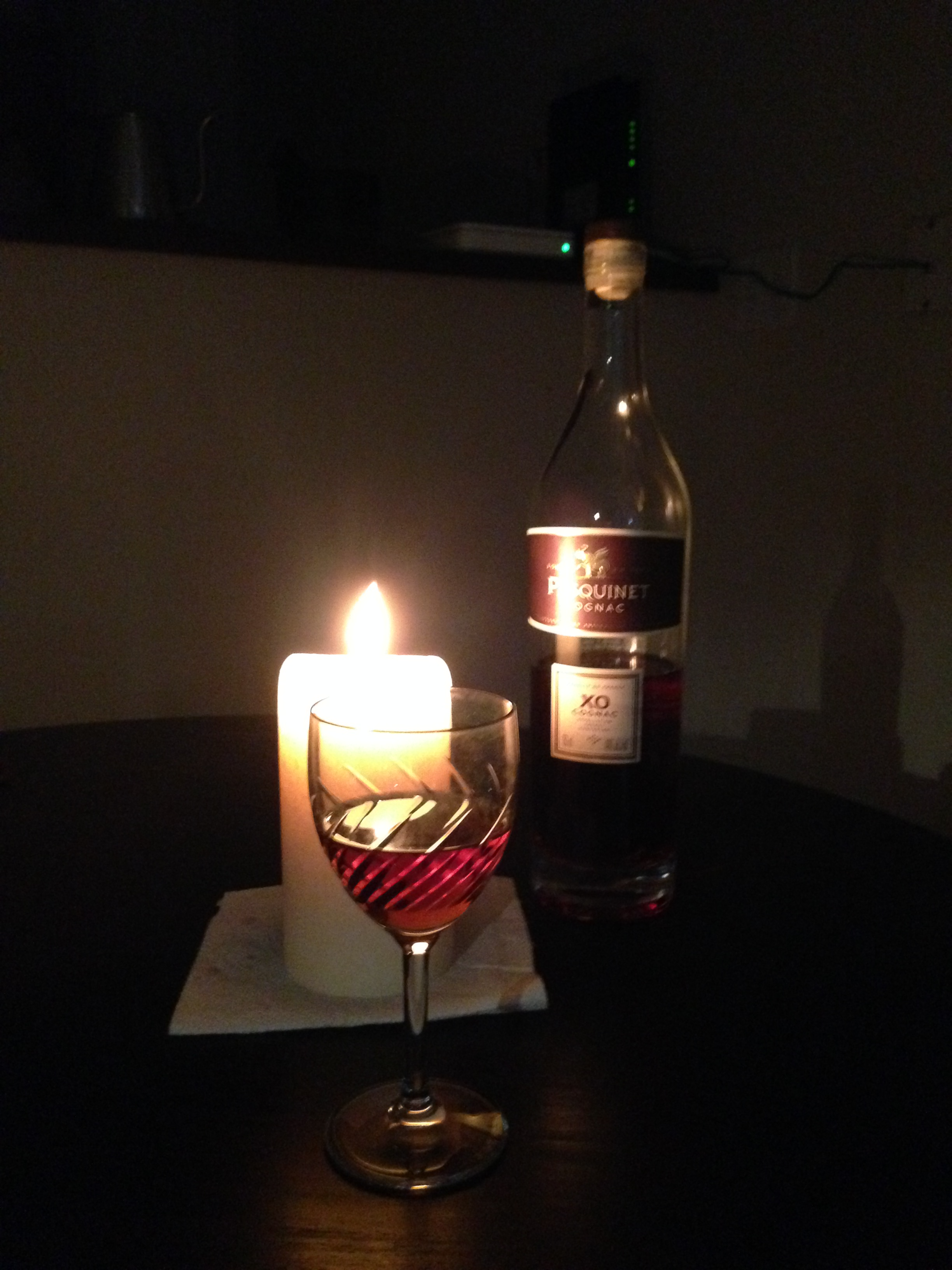 A bottle of Pasquinet, scented candle, and dry cheese.